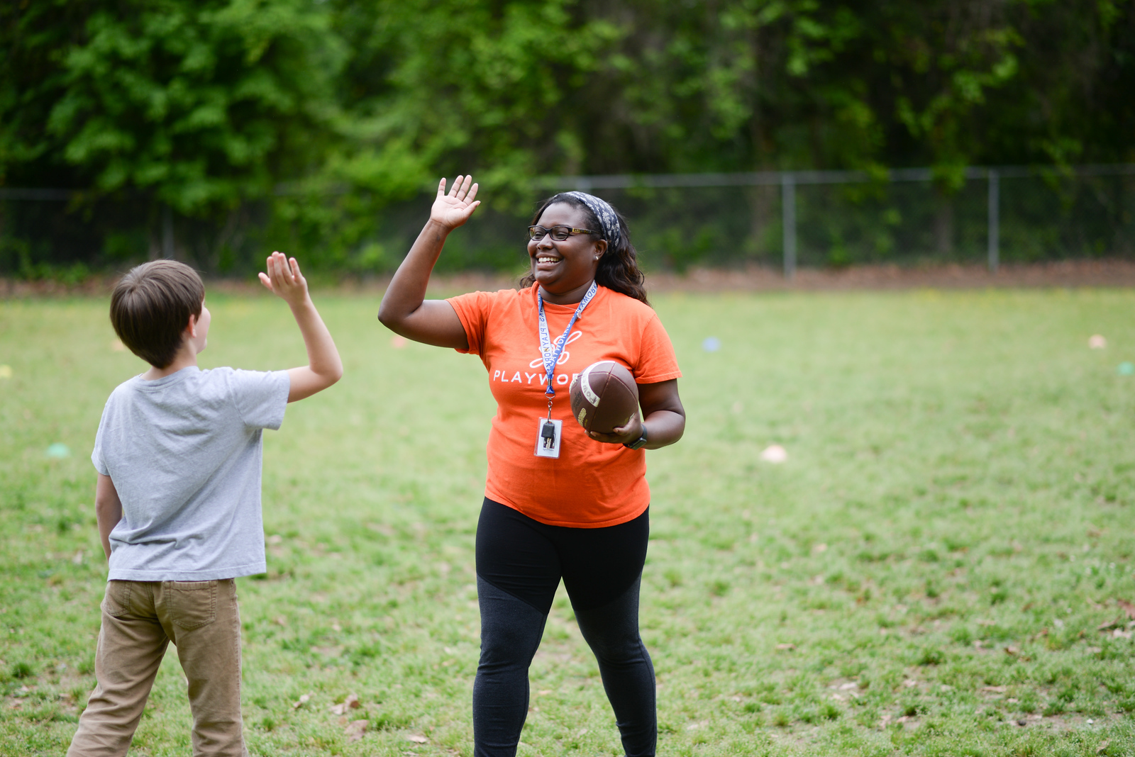 coach and student playing catch, high five