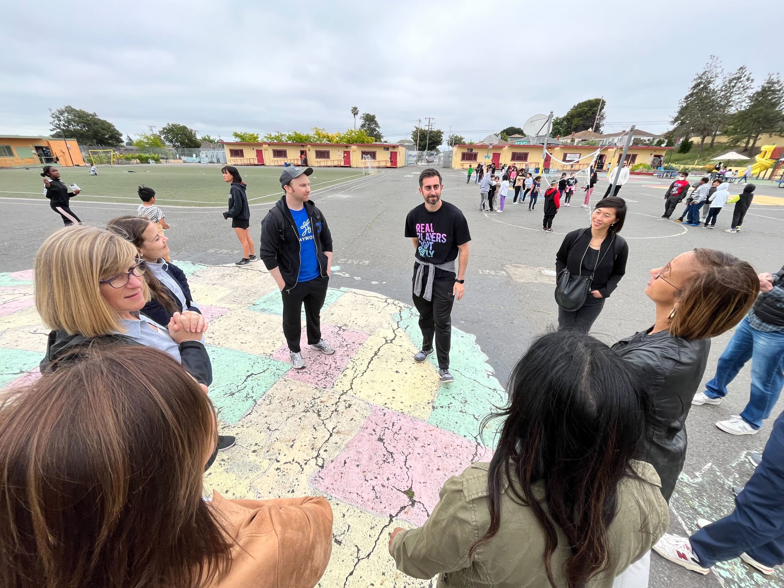 students and adults on playground