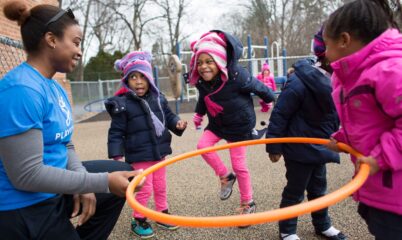 coach and kids playing with hula hoop